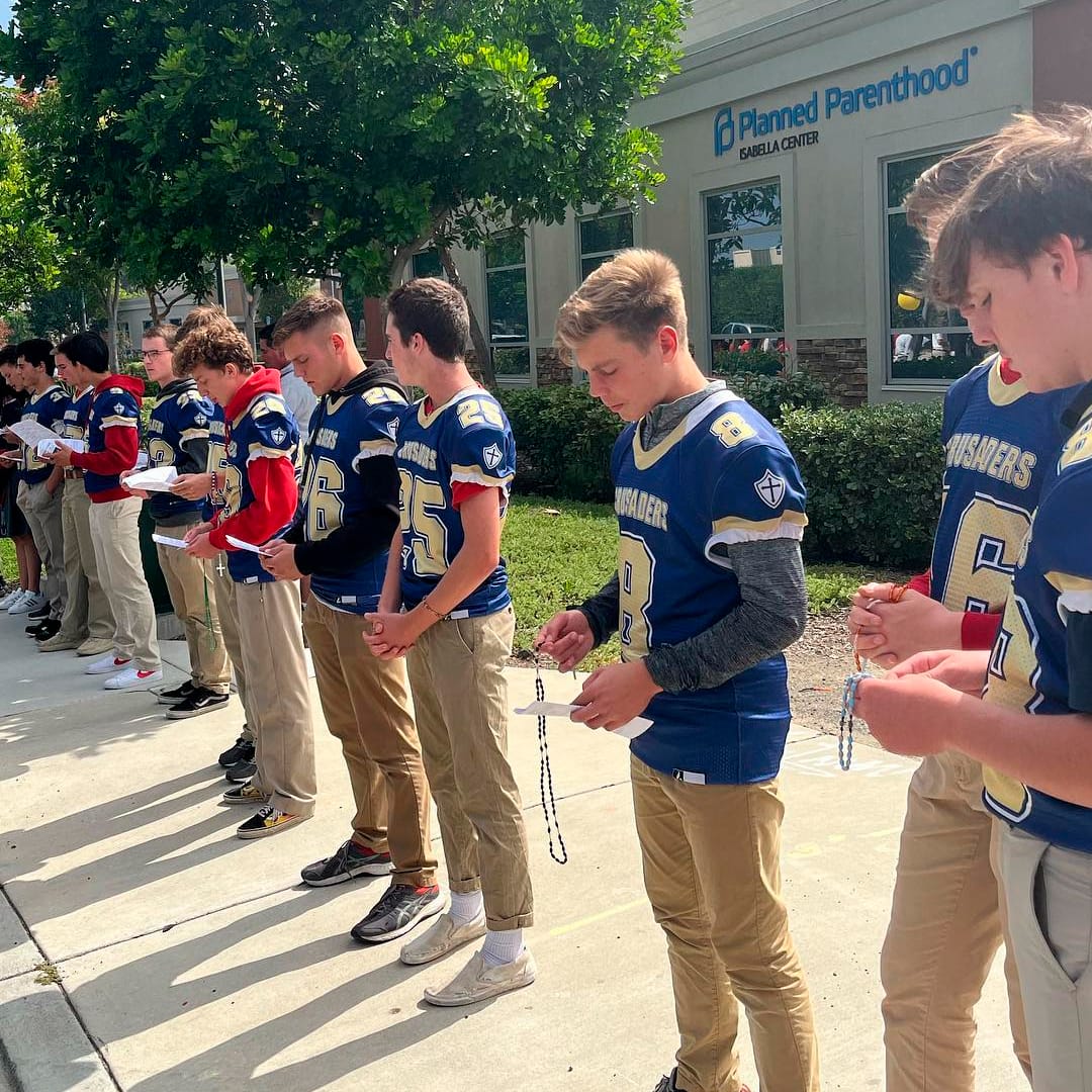 ¡Sí a la vida! Jóvenes de equipo de fútbol americano rezan el rosario frente a clínica abortista