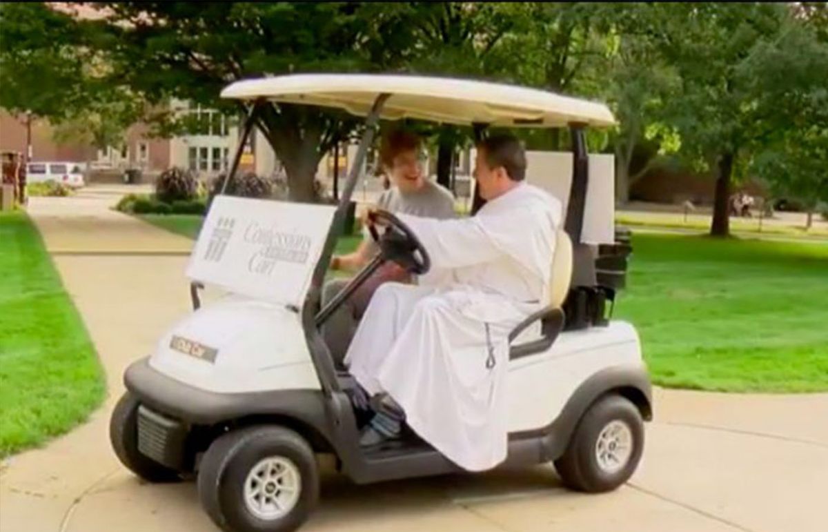 Sacerdote ofrece confesión en un carrito de golf por campus universitario